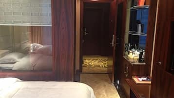 Een hotelkamer met een bed, een kledingkast, een spiegel en een zithoekje.