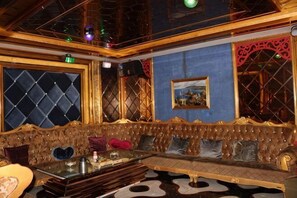 Una camera lussuosa con un'ampia e decorata poltrona, un tavolino in vetro e un quadro appeso al muro.