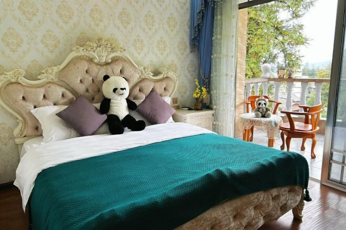 A bed with a green bedspread, a plush panda toy, and a decorative headboard.