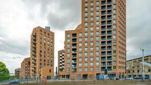 Een modern hoog gebouw met meerdere verdiepingen, met een gelijkmatige bakstenen gevel en tal van ramen.