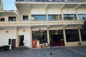 Un edificio de dos plantas con un balcón en el piso superior.