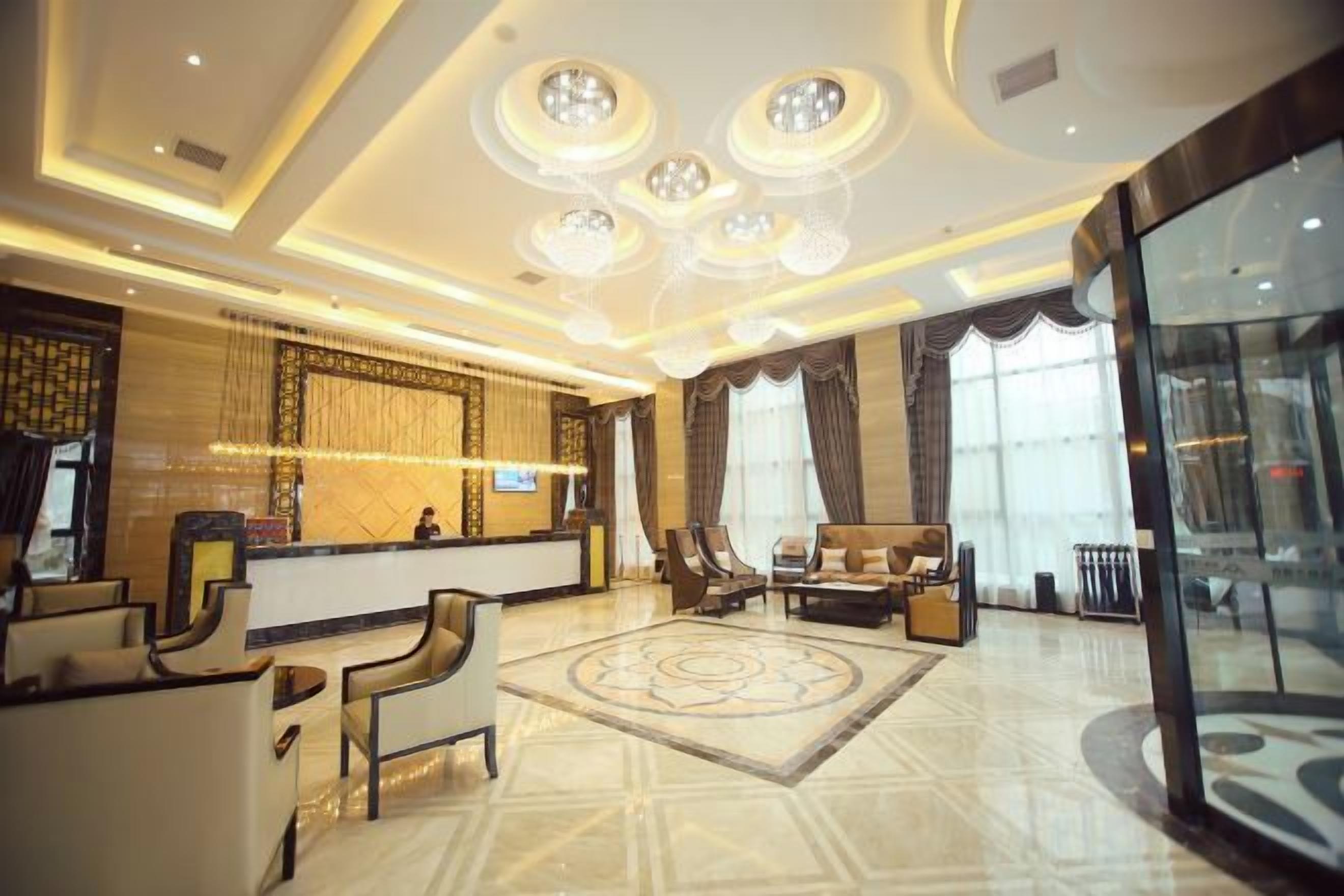 Un hall de hotel con mostrador de recepción, zona de estar y amplias ventanas.