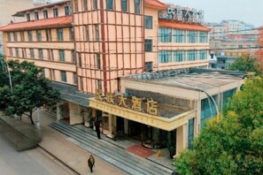 A hotel with a modern facade, a visible entrance, and a staircase leading to the entrance. - National Hotel (Daozhen)
