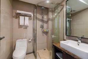 A modern bathroom with a glass-enclosed shower, a white toilet, and a sink with a marble countertop. - National Hotel (Daozhen)
