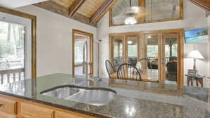 A kitchen with granite countertops, wooden cabinets, and a large sink.
