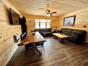 Relax in this inviting space with a dining table, comfortable sofa, and wooden bench.