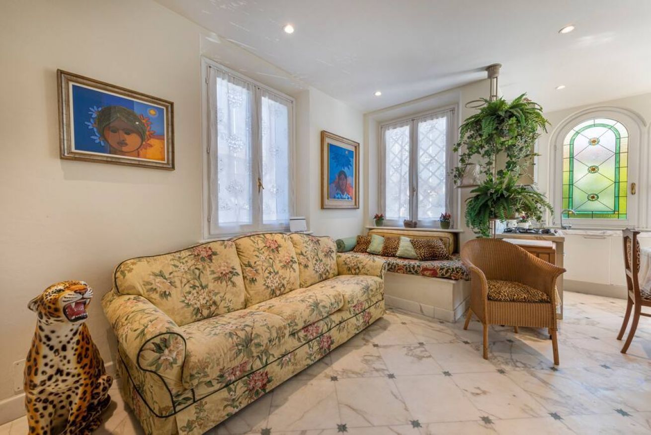 A living room with a floral sofa, a leopard statue, and a green plant.