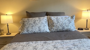 A bed with floral bedding, two framed pictures on the wall, and bedside lamps. - NO STAIRS!  Walk-in condo, Golf Course View, No pets allowed.  (Branson)