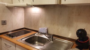 A kitchen with a stainless steel sink, a stove, and cabinets. - 601 NEVADA 2 -estudi 2 pers- balco-Pas de la Casa -007647 (Pas de la Casa)