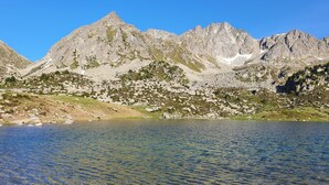 A mountain landscape with a clear lake in the foreground and rocky mountains in the background. - 601 NEVADA 2 -estudi 2 pers- balco-Pas de la Casa -007647 (Pas de la Casa)
