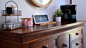 A wooden dresser with a vintage clock, a coffee bar sign, a Keurig coffee maker, and a small potted plant. - 1 BR Walk in! No Cleaning Fees! Pools/hot tub! WAFFLES! Beach Pass! (Branson)