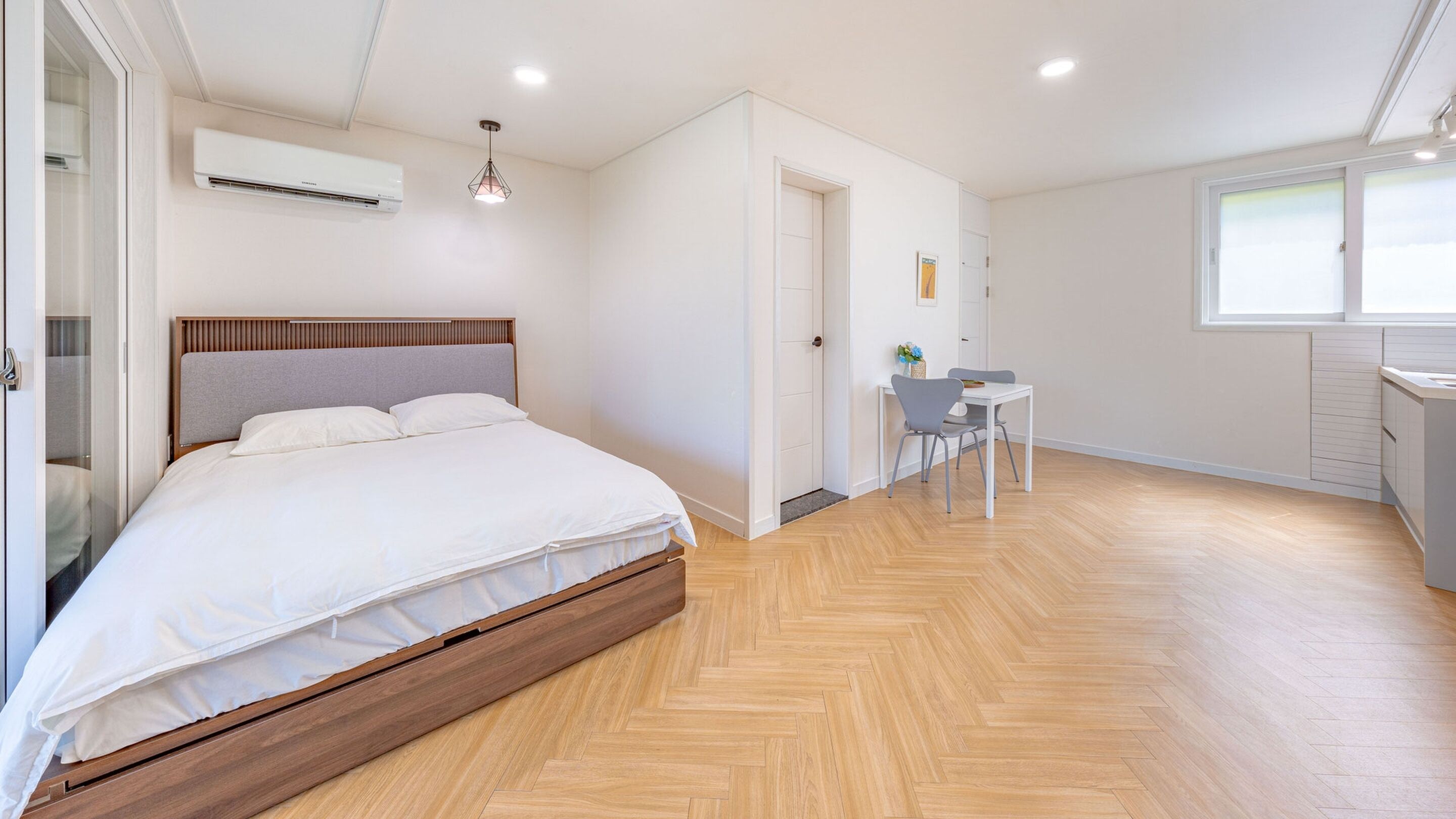 A bedroom with a wooden bed, a small desk, and a chair.
