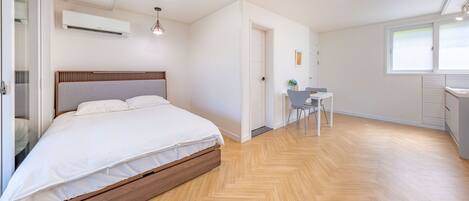 A bedroom with a wooden bed, a small desk, and a chair.