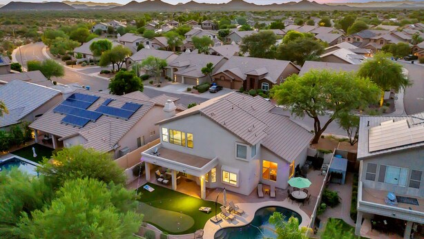 Zona residencial com casas, piscina e painéis solares.