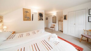 A hotel room with two beds, a dresser, a chair, and artwork on the walls. - Earnside Cottage, Tranquil Escape in Comrie (Comrie)
