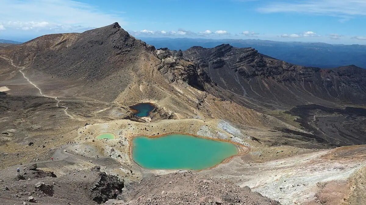 A mountainous landscape with a prominent peak and two turquoise lakes.