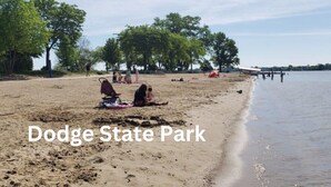 Une scène de plage au parc d’État de Dodge, où l’on voit des personnes se détendre et une poussette.