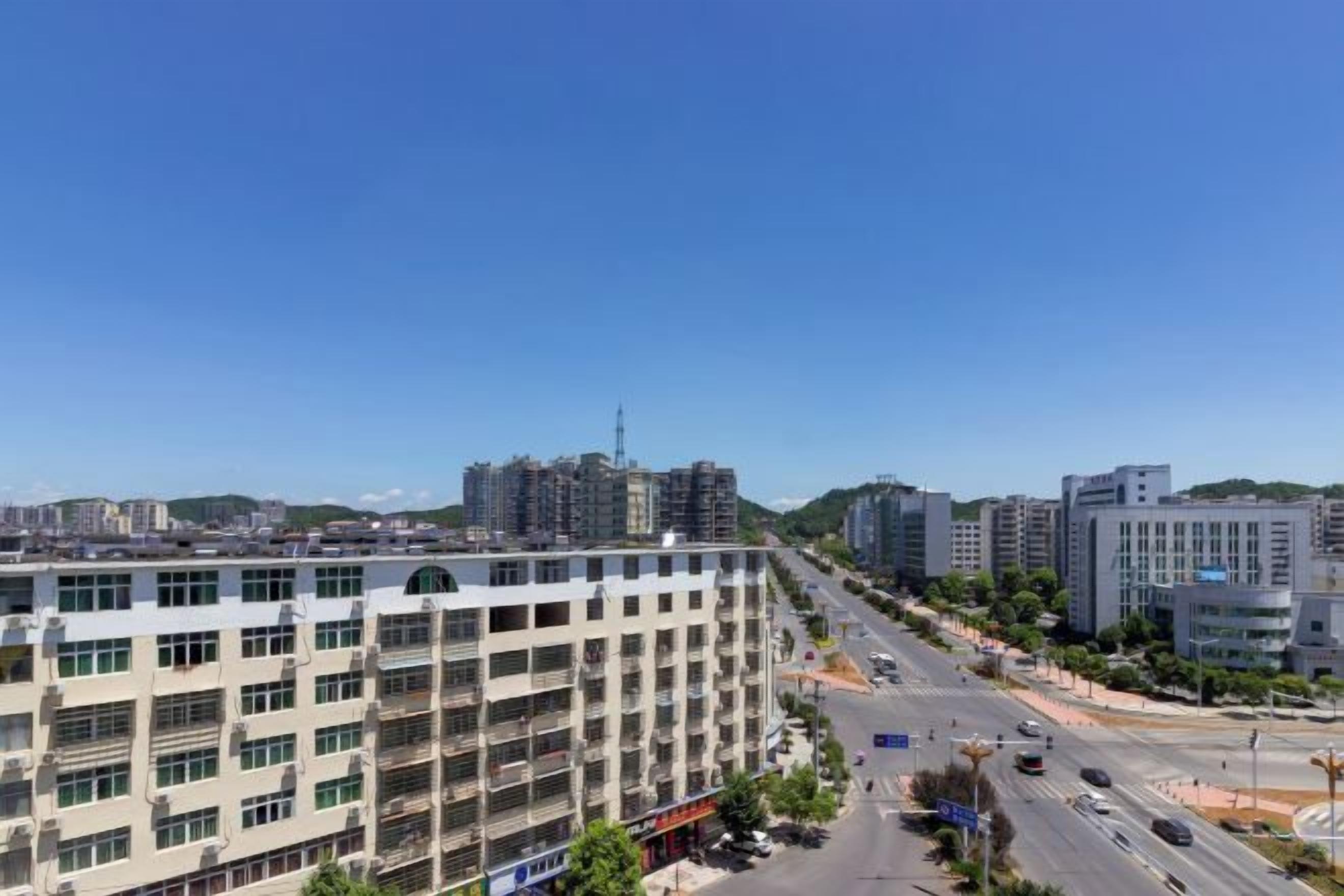 A multi-story building with a modern architectural style, located in an urban setting with a clear sky.