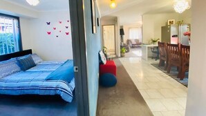 A bedroom with a bed, a red ottoman, and a wall with butterfly decals. - Entire Home In Werribee On the Best Possible Location. (Werribee)