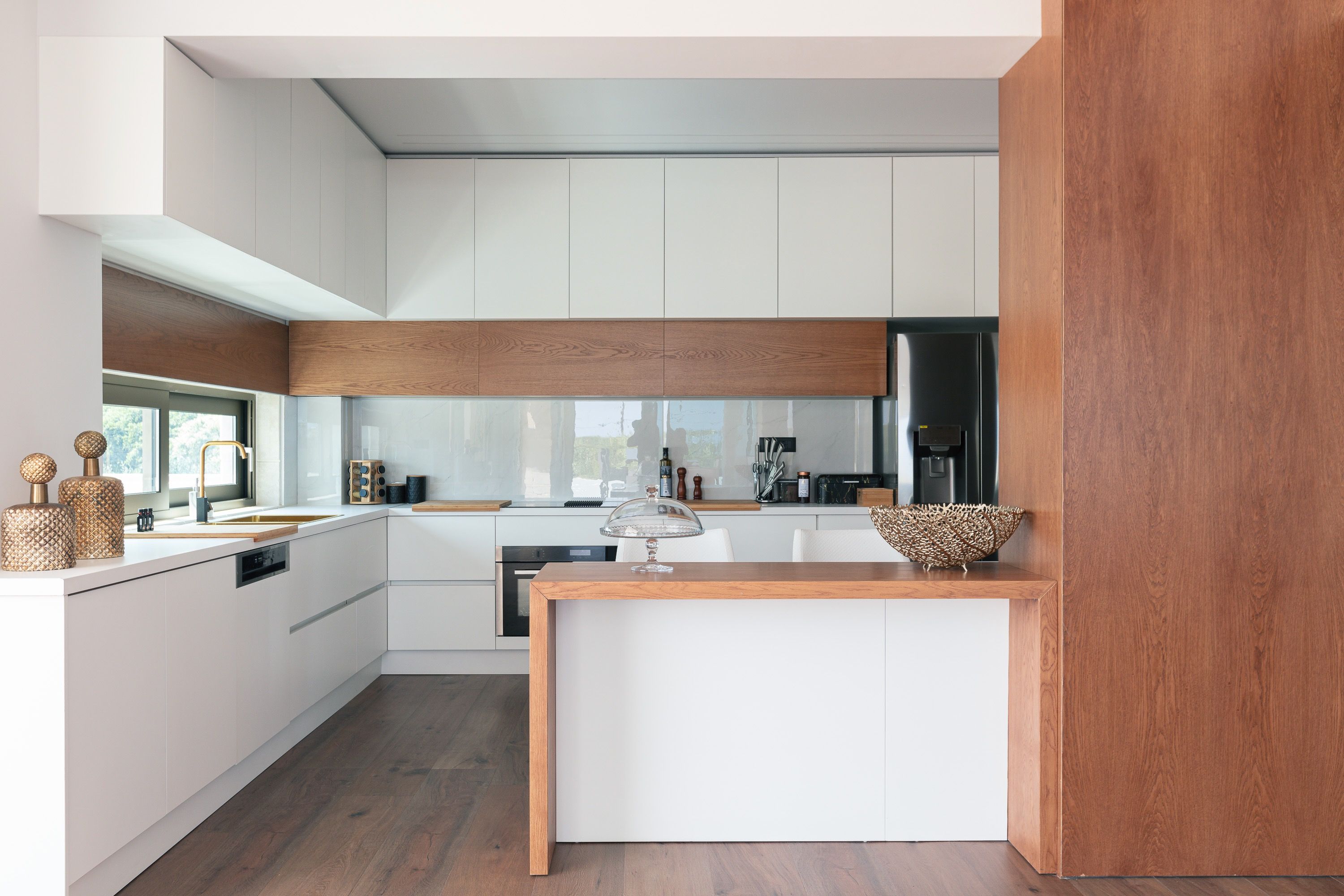 A modern kitchen with white cabinetry, a wooden countertop, and a central island.
