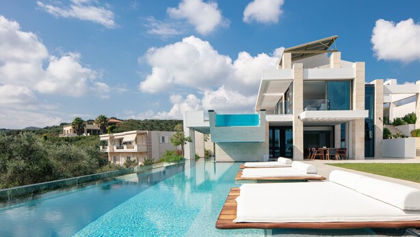 A modern poolside area with lounge chairs and a clear view of a contemporary building with a glass facade. - 250m2 pool, Daily Housekeeping, Spa, 300m to beach and Shops: by etouri (Chania)
