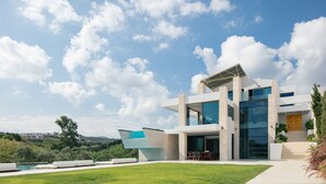 A modern house with a large glass facade, a boat-shaped extension, and a well-maintained lawn. - 250m2 pool, Daily Housekeeping, Spa, 300m to beach and Shops: by etouri (Chania)