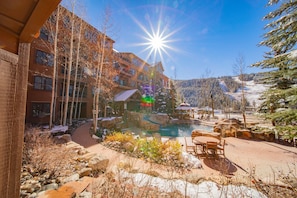 A resort with a pool, outdoor seating, and a mountain backdrop. - Springs 8811 (Keystone)