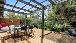 An outdoor patio with a wooden deck, a metal pergola, and a dining table with chairs. - Rye Beach Abode - STAY 3 PAY 2 SPECIAL OFFER! Expires 1st September 2025 (Rye)