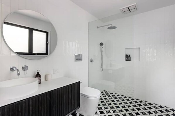 A modern bathroom with a round mirror, a sink, a toilet, and a shower. - Rye Beach Abode - STAY 3 PAY 2 SPECIAL OFFER! Expires 1st September 2025 (Rye)