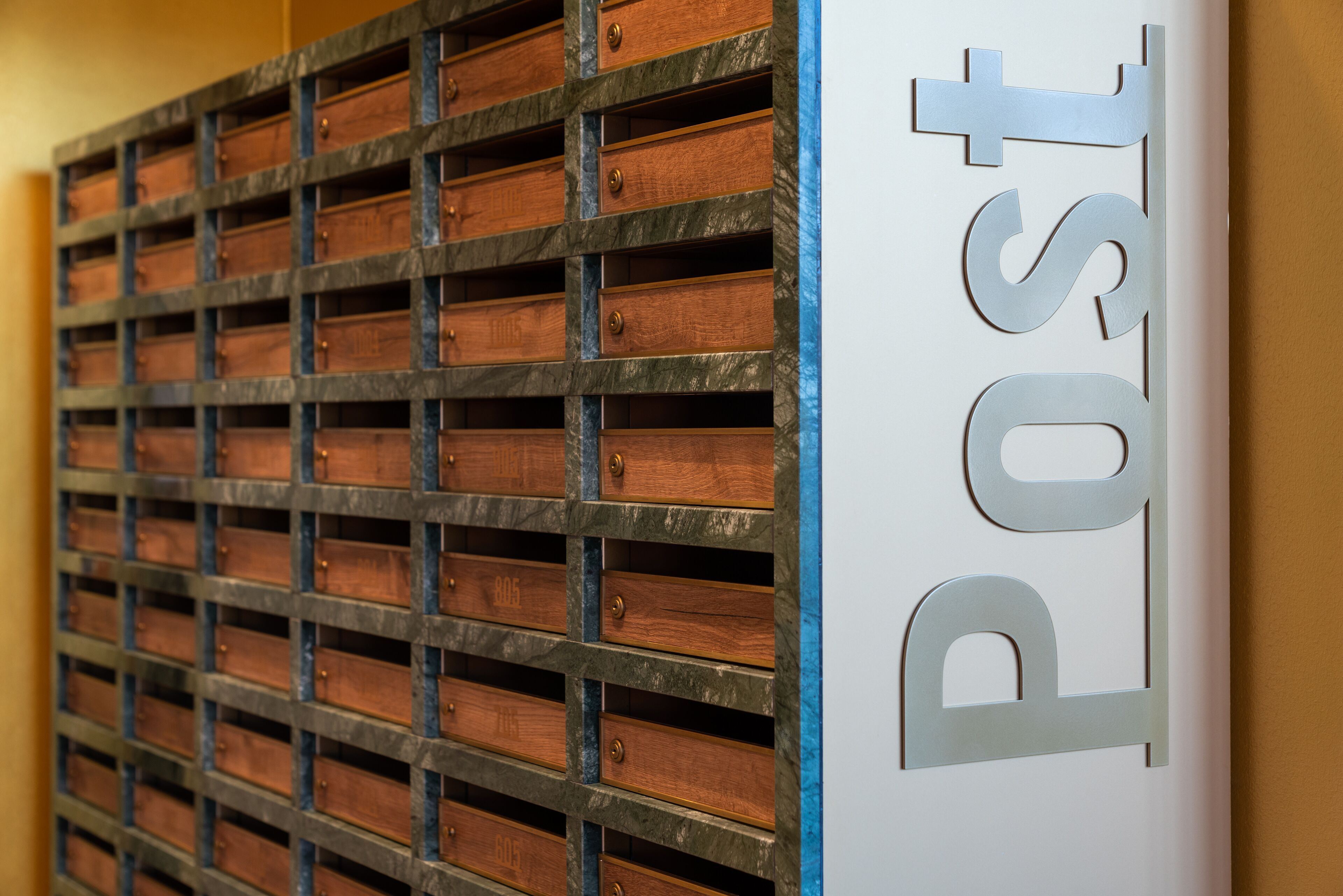 Una pared con una serie de cajones de madera y un cartel con la palabra 'Post'.