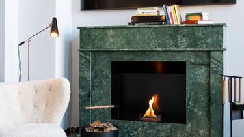 Una sala de estar moderna con chimenea, televisor de pantalla plana y un rincón de descanso acogedor.