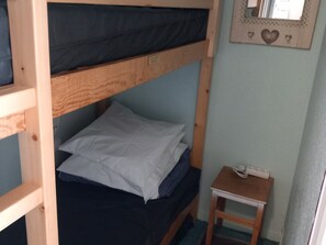 A bunk bed room with a small bedside table and a mirror on the wall. - Studio Cabin in Tignes Le Lac with Balcony and Ski Locker (Tignes)