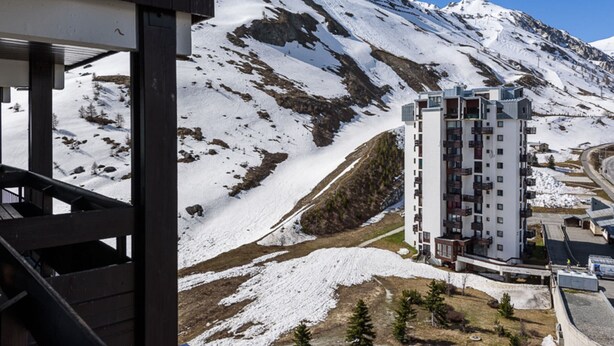 Un bâtiment moderne avec une montagne enneigée en toile de fond.