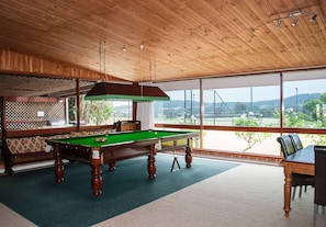 A pool table in a room with wooden ceiling and large windows. - Bluebush Estate - The Lodge (Rothbury)