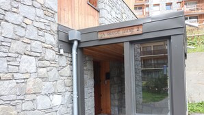 Un edificio de piedra con un letrero de madera que dice "LA GRANDE BALME 2".