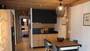 Una cocina moderna con armarios de madera, encimera negra y lámpara colgante.