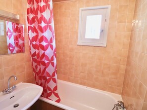 A bathroom with a sink, a bathtub, and a shower curtain. - Functional Studio Near Slopes with Balcony (Tignes)