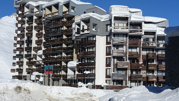 A multi-story hotel with balconies and a snow-covered exterior.