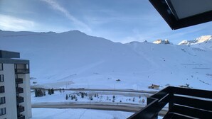 A snow-covered mountain landscape with a building in the foreground.