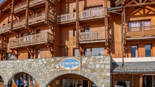 A wooden chalet with multiple balconies and a stone entrance. - Charming 56m2 apartment for 6 with balcony and parking - Val Thorens (Val Thorens)