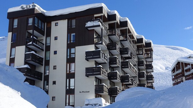 A multi-story hotel with balconies, surrounded by snow.