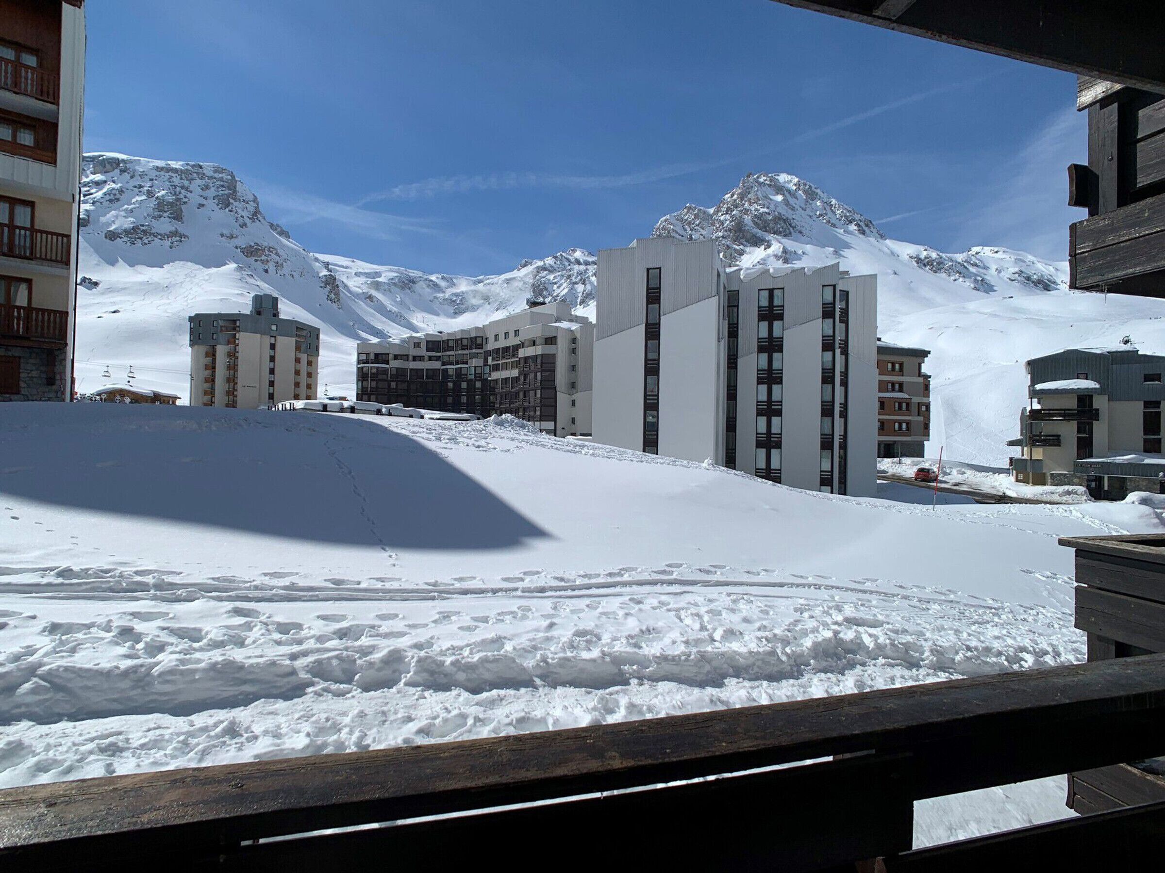 A snow-covered mountain with modern buildings in the background.