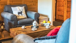 A cozy living room with a grey armchair, a wooden coffee table, and a basket of fruit. - Renovated ski-in ski-out apartment, balcony, WIFI, 4 bedrooms (Tignes)