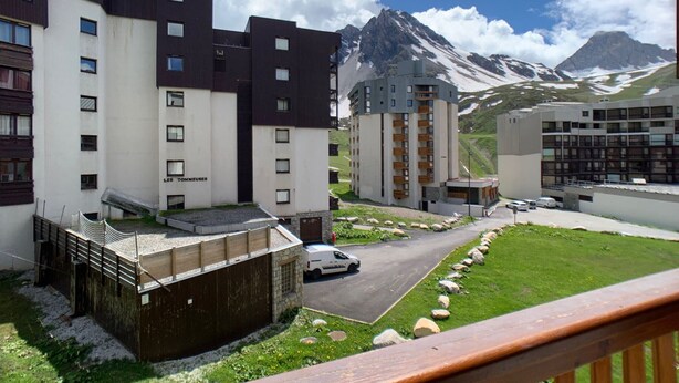 Ein moderner Hotelkomplex mit mehreren Gebäuden, einem Parkplatz und einer Bergkulisse.