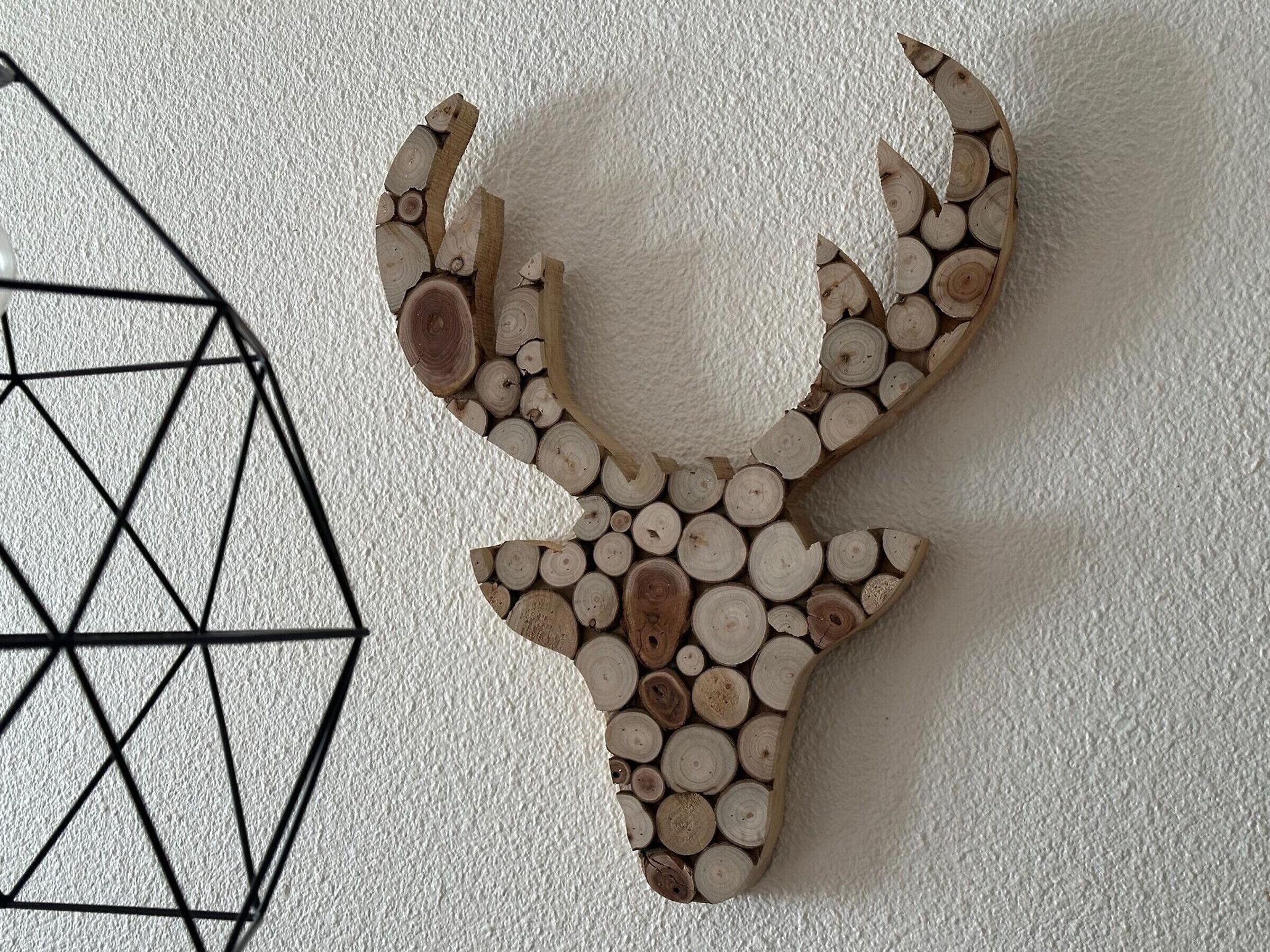 Adorno de madera en la pared, con forma de cabeza de ciervo.