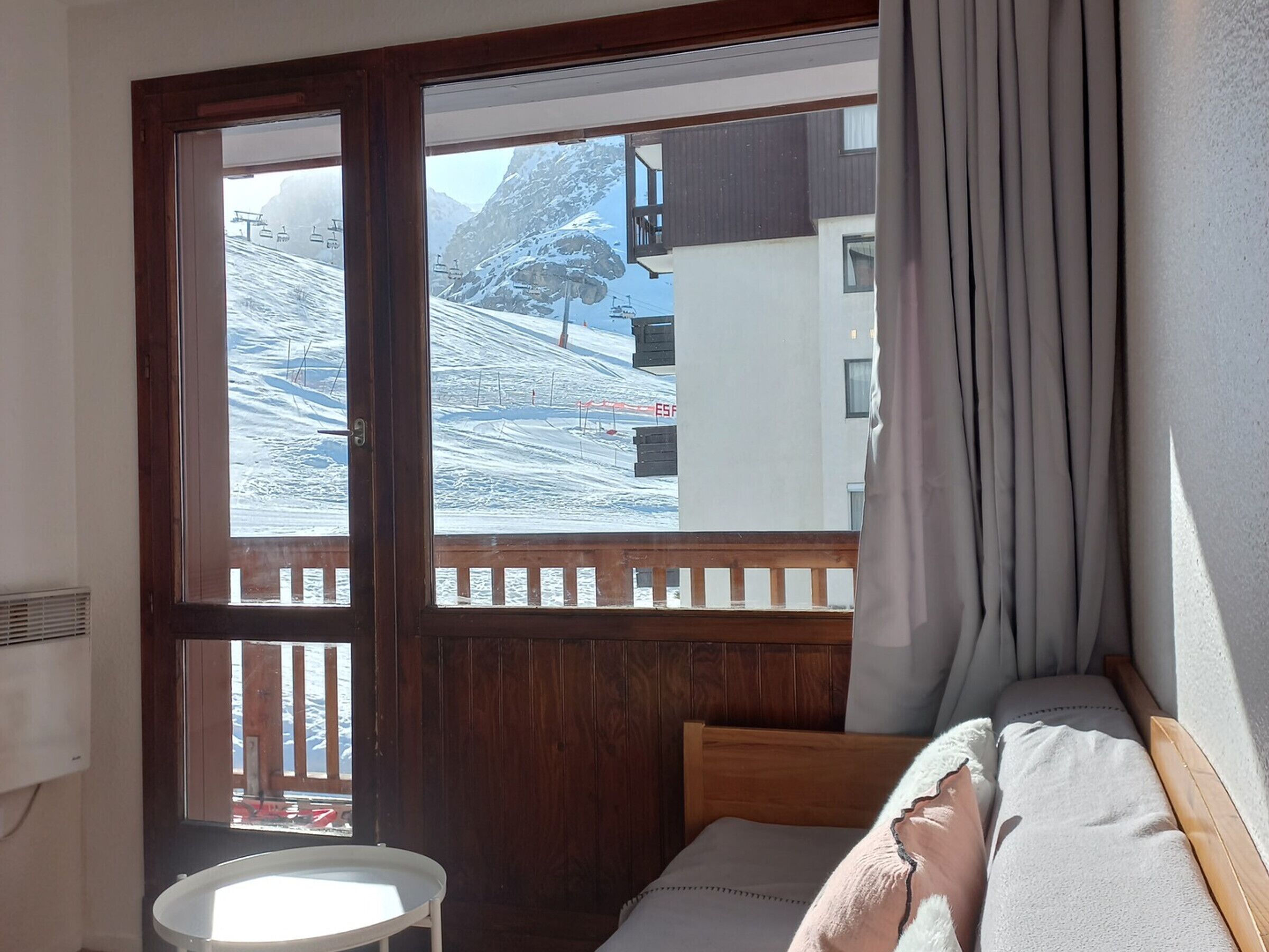 Une chambre avec une grande fenêtre donnant sur une montagne enneigée.