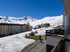 Paesaggio montuoso innevato con edifici e cielo sereno.