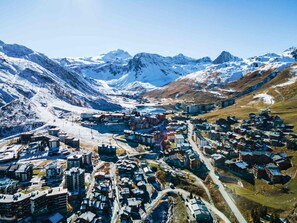 A mountainous town with snow-covered peaks, a mix of modern and traditional buildings, and a clear sky.