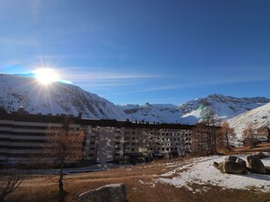 Un hotel con le montagne sullo sfondo, caratterizzato da un edificio ampio con diversi piani e tetto piatto.