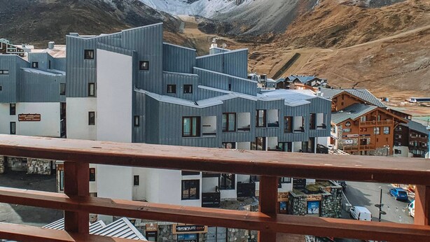 Un hotel moderno con un diseño arquitectónico único, con varios niveles y un balcón destacado.